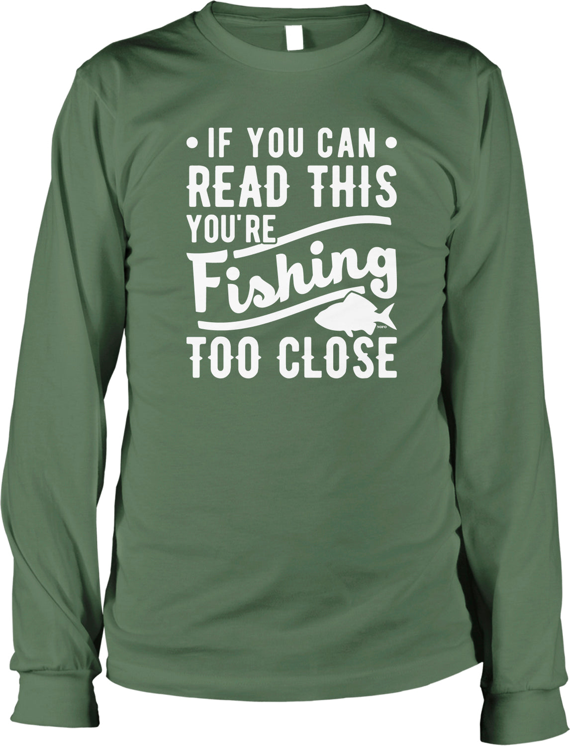 The image is a green long-sleeved t-shirt with white text printed on it. The text reads, "If you can read this, you're fishing too close".