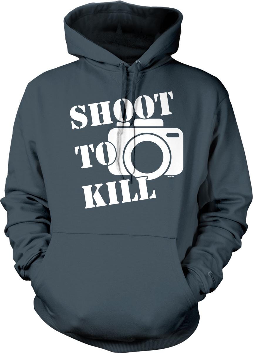 A gray hoodie with the text "SHOOT TO KILL" printed on it, along with a graphic of a camera.