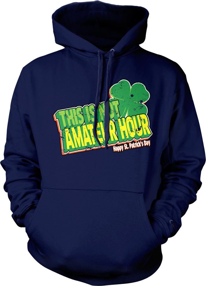 A navy blue hoodie with a graphic design featuring a clover and text that reads "This is not a happy St. Patrick's Day".