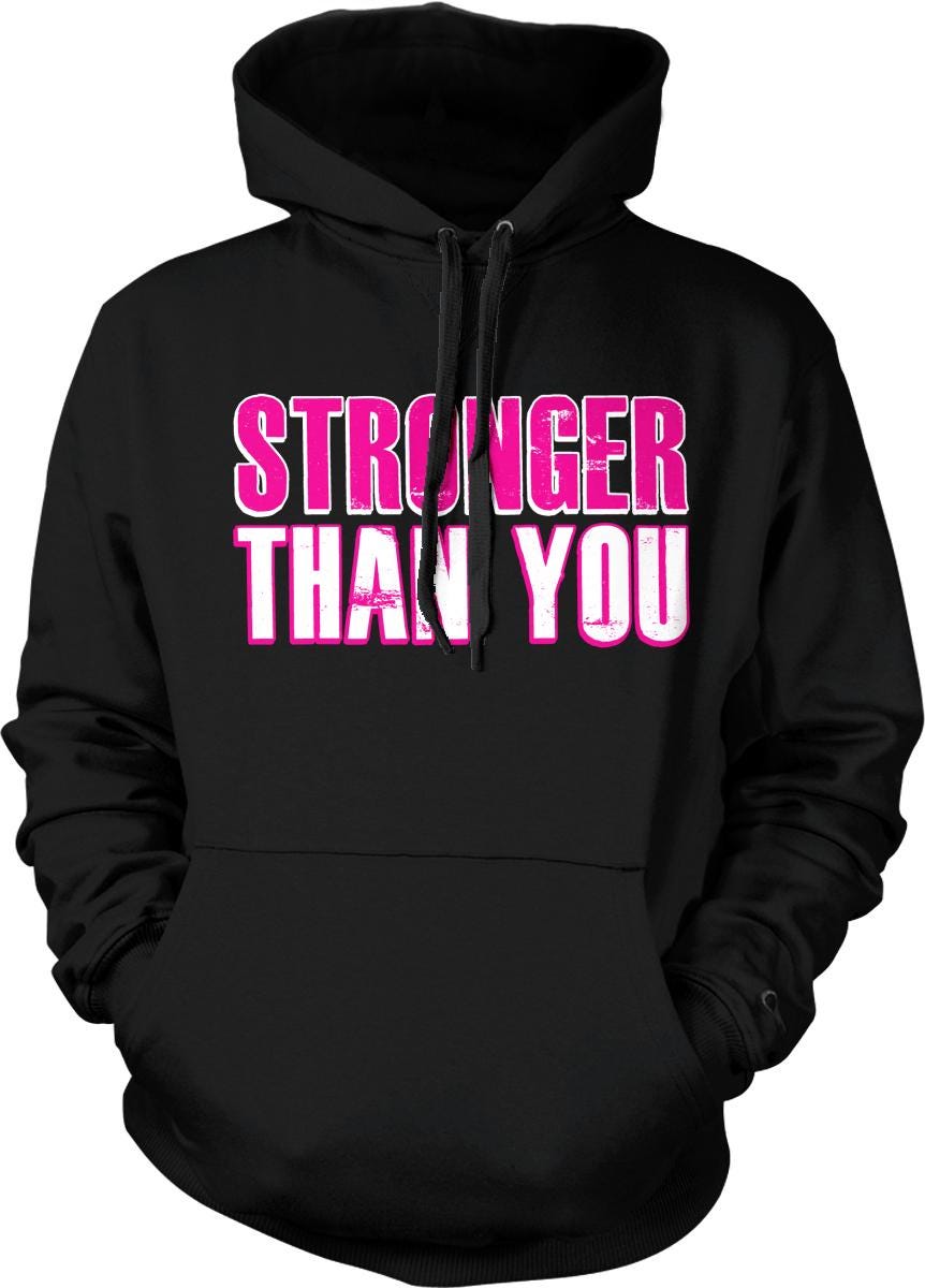 A black hoodie with the text "STRONGER THAN YOU" printed in pink and white letters.