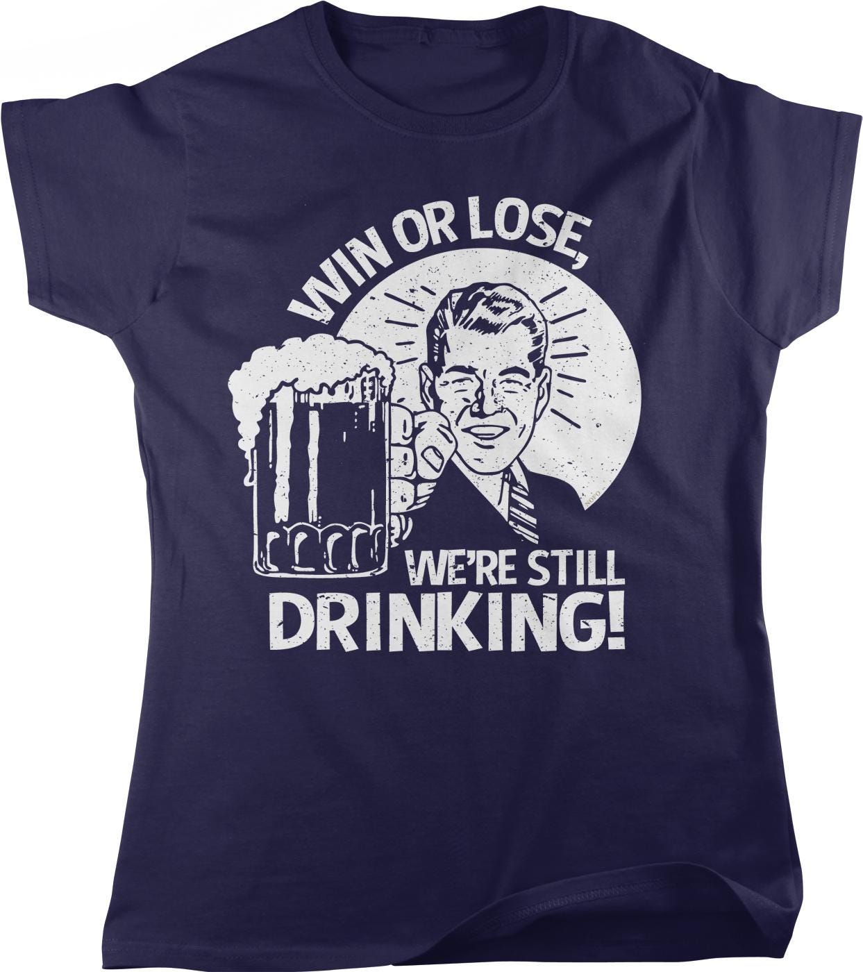 A t-shirt with a graphic design depicting a man holding a beer mug and the text "WIN OR LOSE WE'RE STILL DRINKING!"