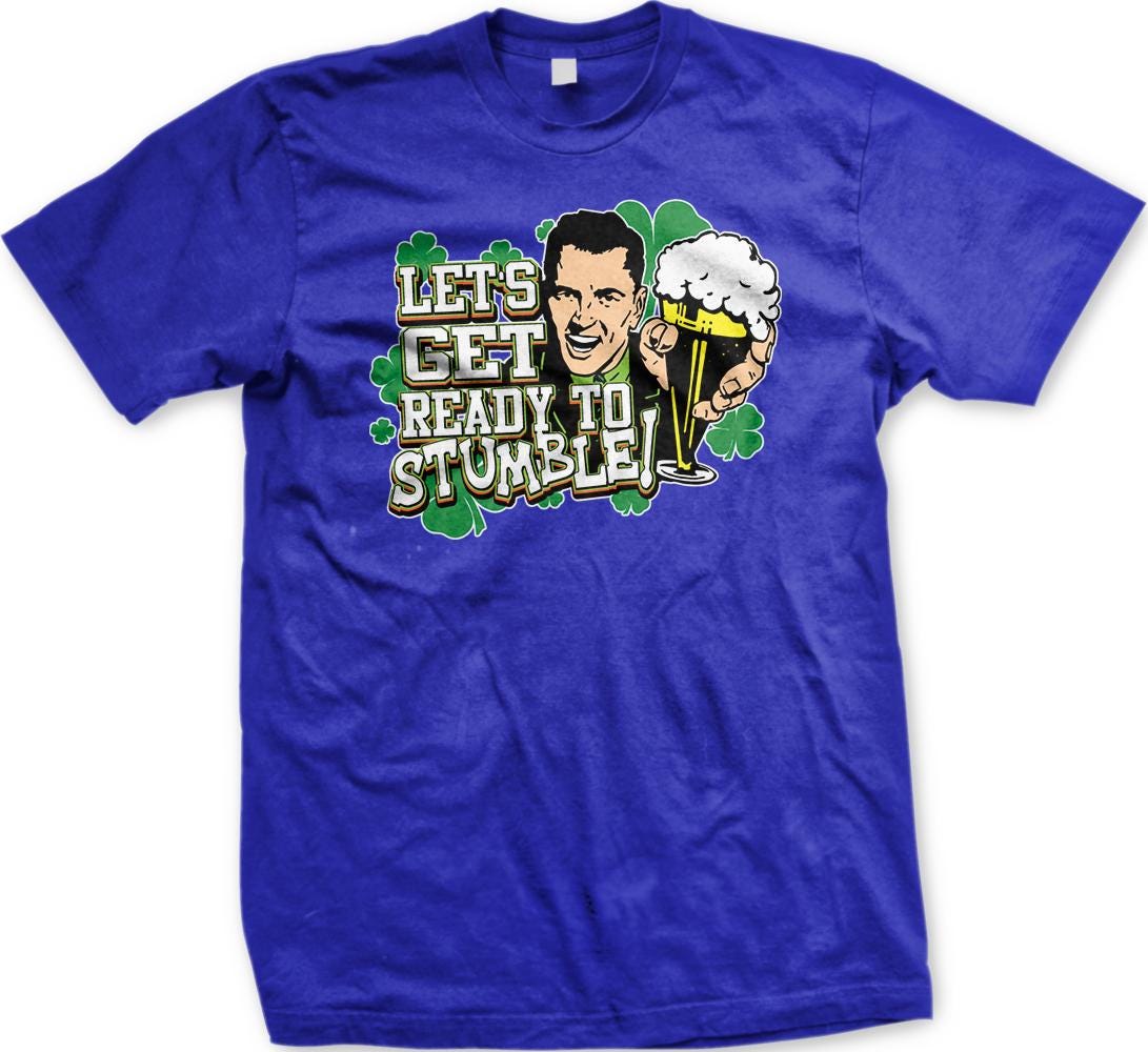 A blue t-shirt with a graphic design featuring a smiling man holding a beer and the text "Let's Get Ready to Stumble!"