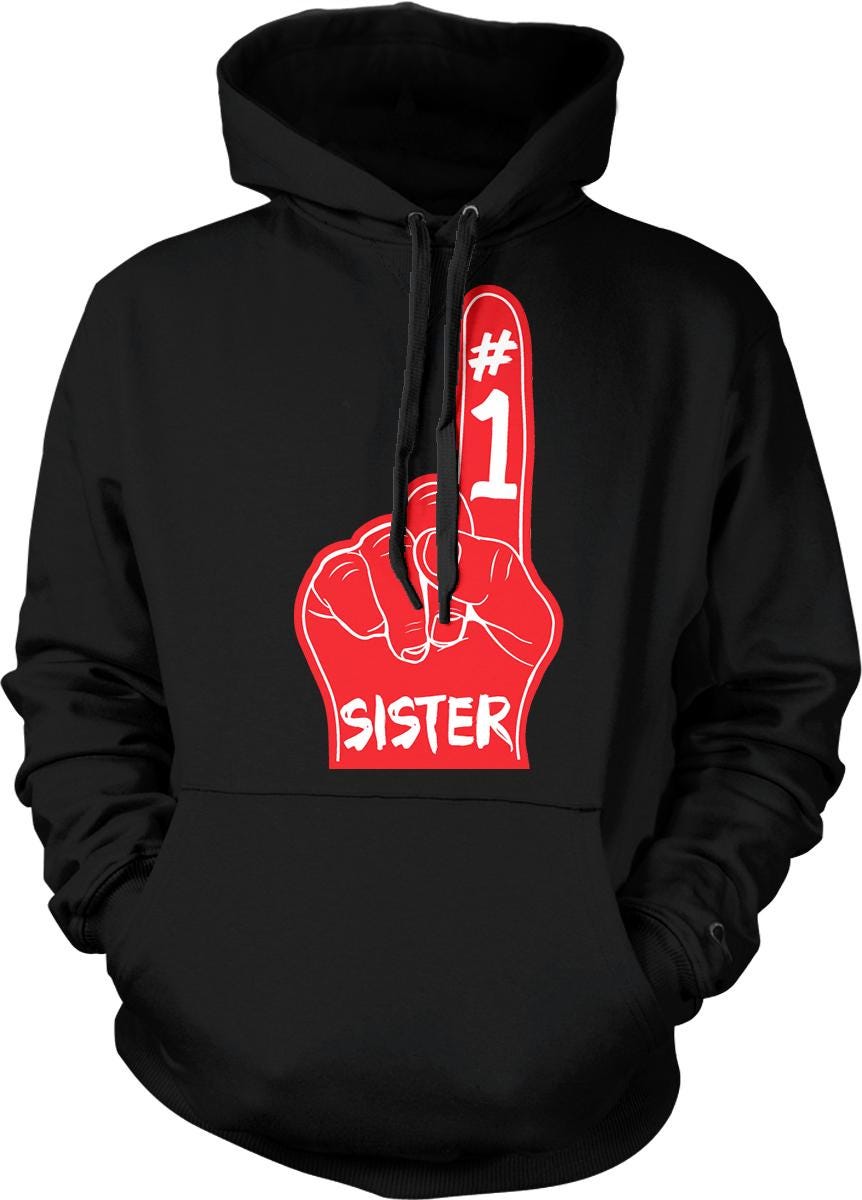 A black hoodie with a red graphic design on the front, depicting a hand with the number 1 and the word "SISTER" written below it.