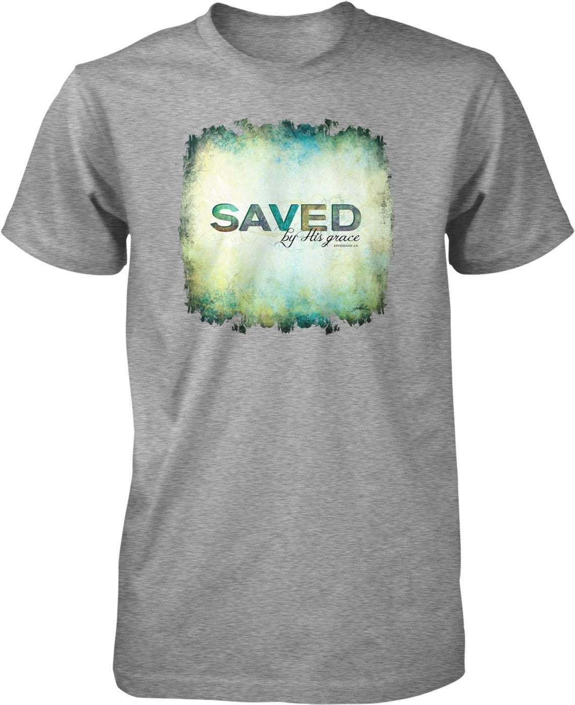 A gray t-shirt with a graphic design featuring the text "SAVED by His grace" in a stylized font.