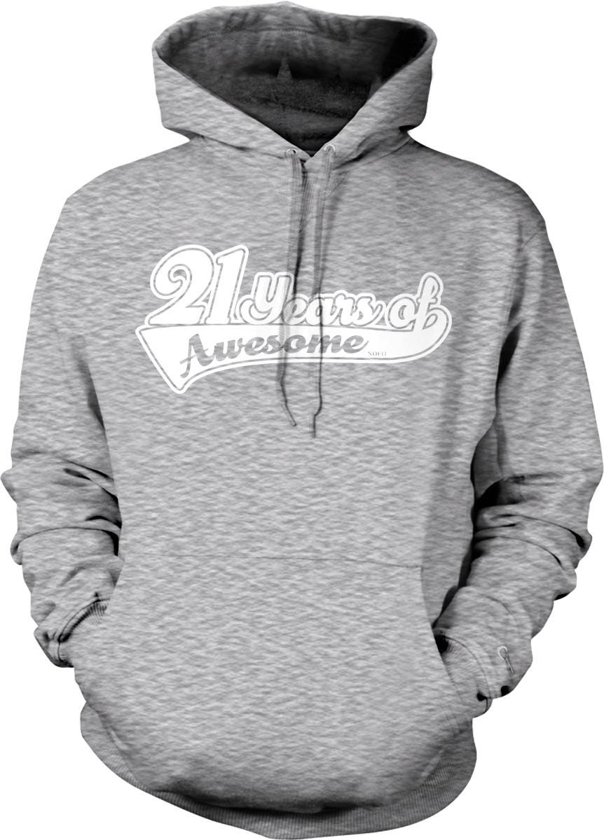 A gray hooded sweatshirt with the text "21 years of Awesome" printed on it.