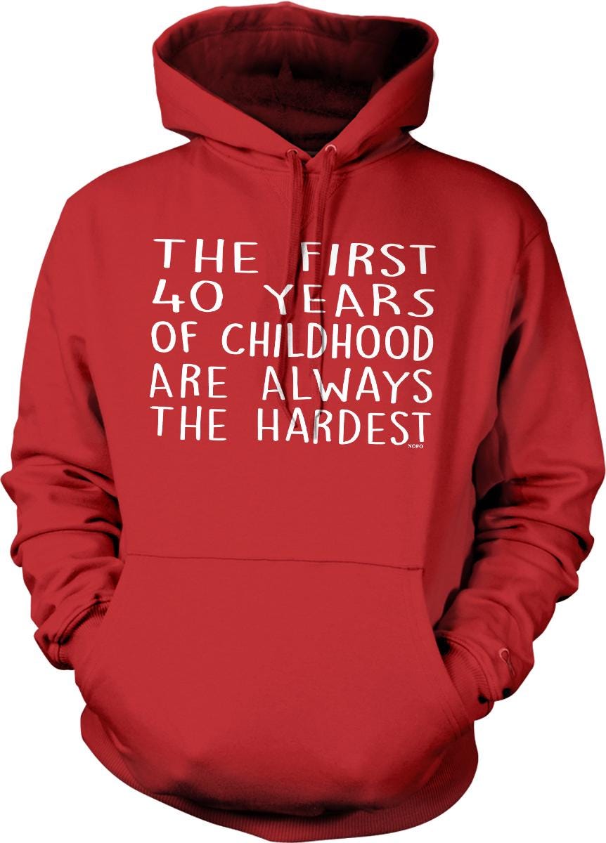 A red hoodie with white text that reads "THE FIRST 40 YEARS OF CHILDHOOD ARE ALWAYS THE HARDEST".