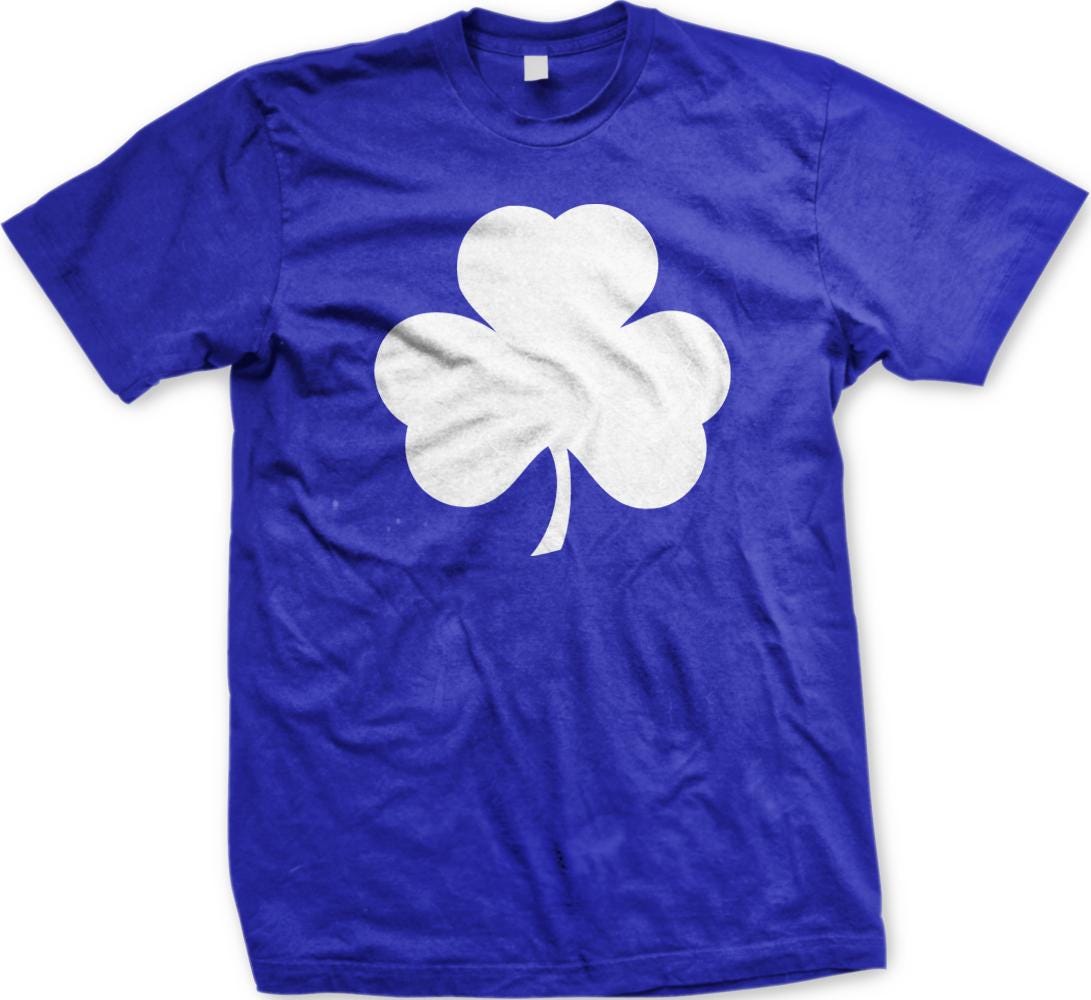 A blue t-shirt with a white clover graphic printed on it.