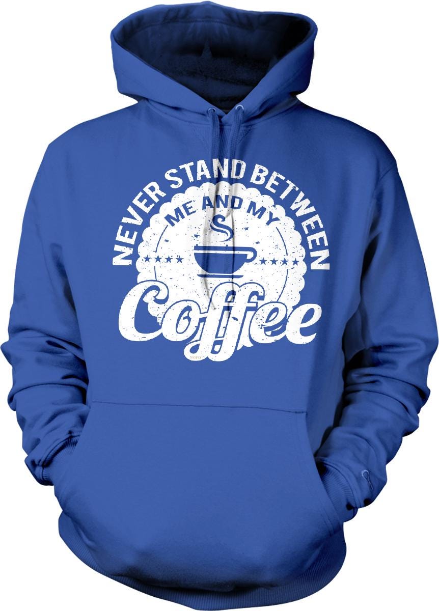 A blue hoodie with a white graphic design that says "NEVER STAND BETWEEN ME AND MY COFFEE" printed on it.