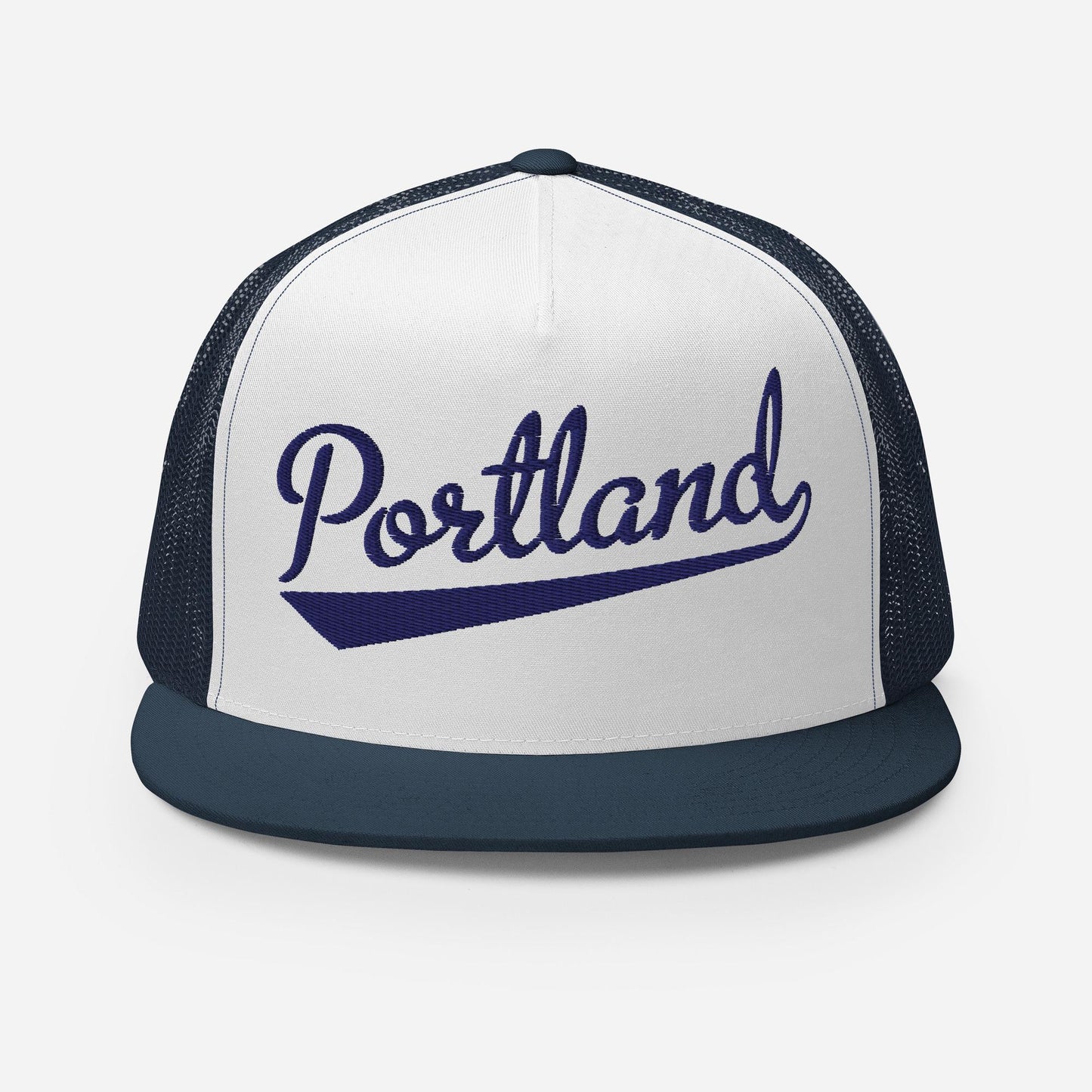 A white and navy blue baseball cap with the word "Portland" printed on it in a cursive font.