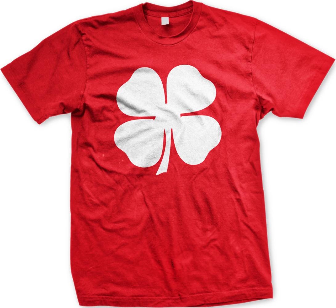 A red t-shirt with a white four-leaf clover graphic printed on it.