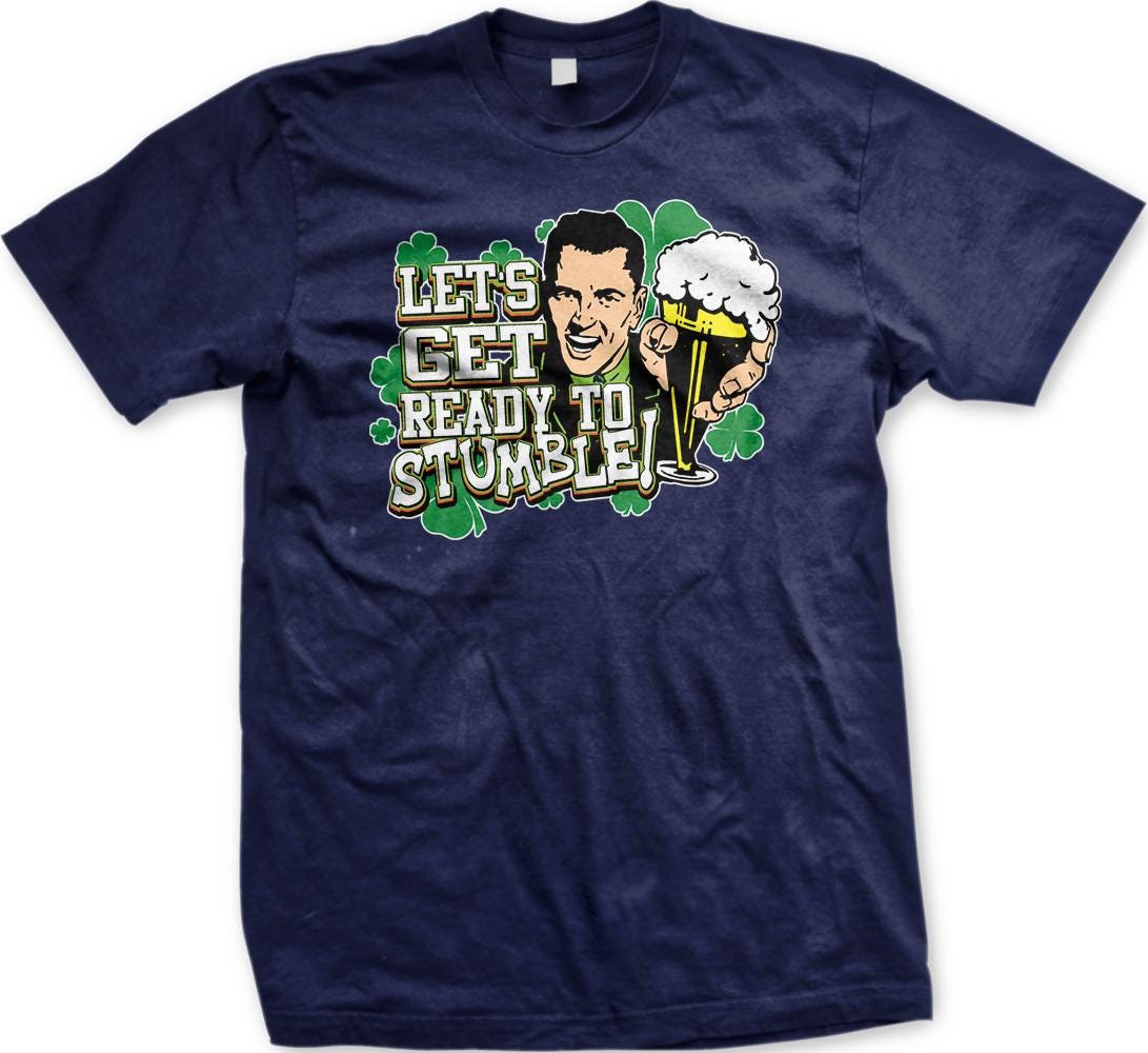 A blue t-shirt with a graphic design featuring a smiling man holding a beer and the text "Let's get ready to stumble!"