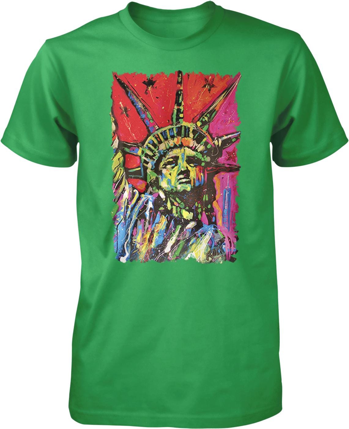 A green t-shirt with a colorful, abstract painting of the Statue of Liberty on it.