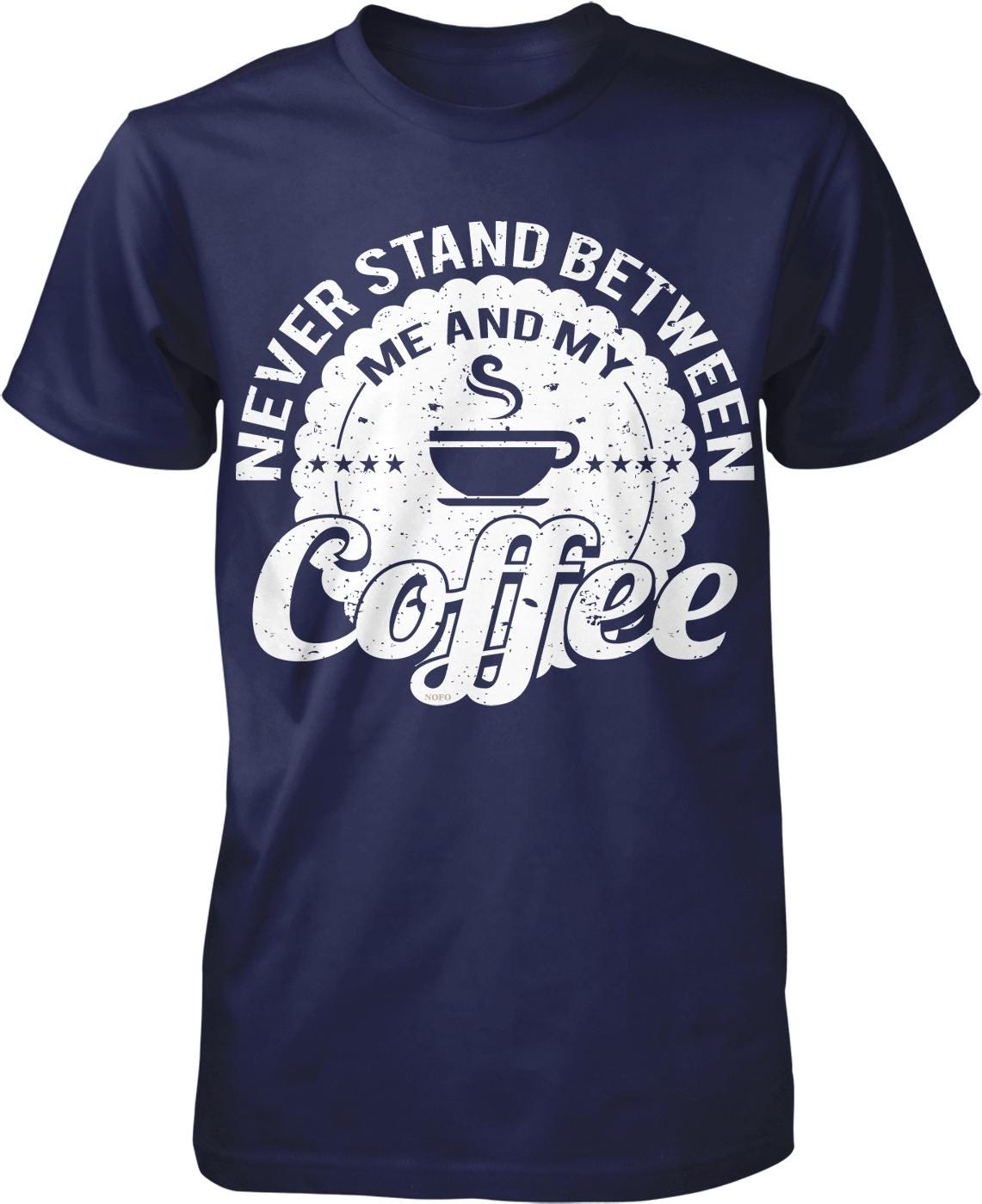 A navy blue t-shirt with a white graphic design that says "NEVER STAND BETWEEN ME AND MY COFFEE" around a coffee cup icon.