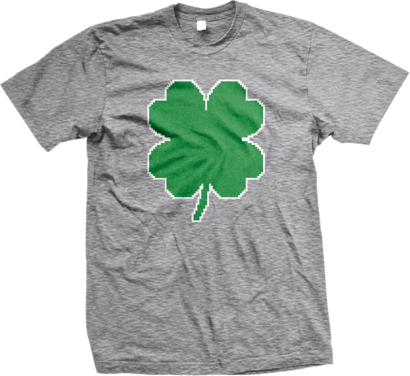 A gray t-shirt with a green pixelated four-leaf clover design printed on it.