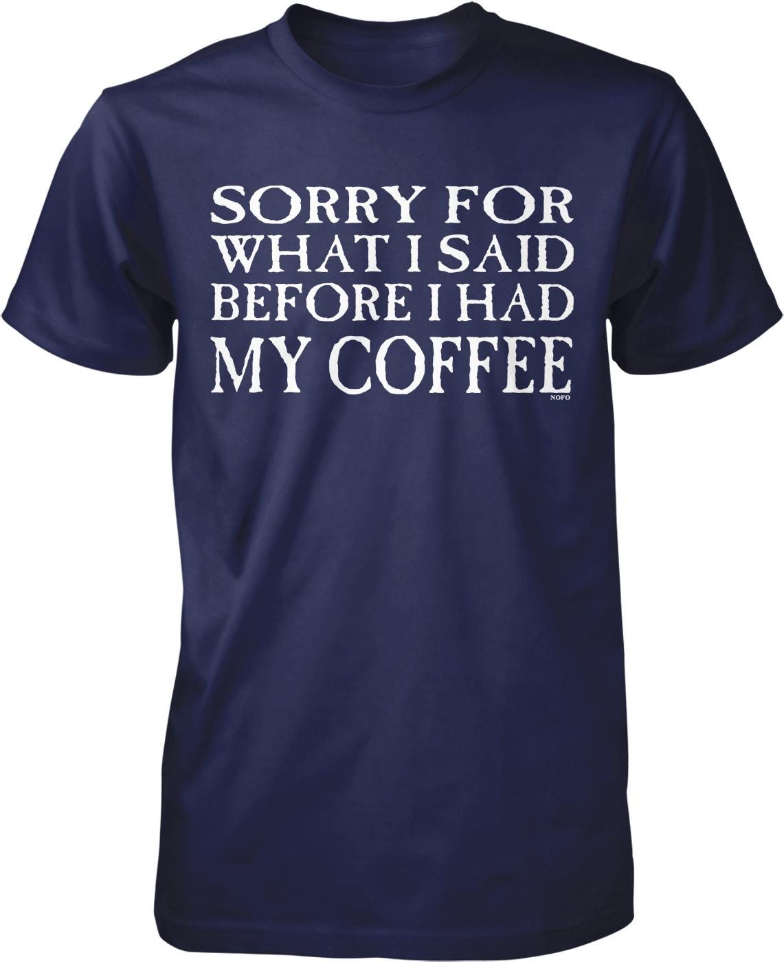 A navy blue t-shirt with white text that reads "SORRY FOR WHAT I SAID BEFORE I HAD MY COFFEE".