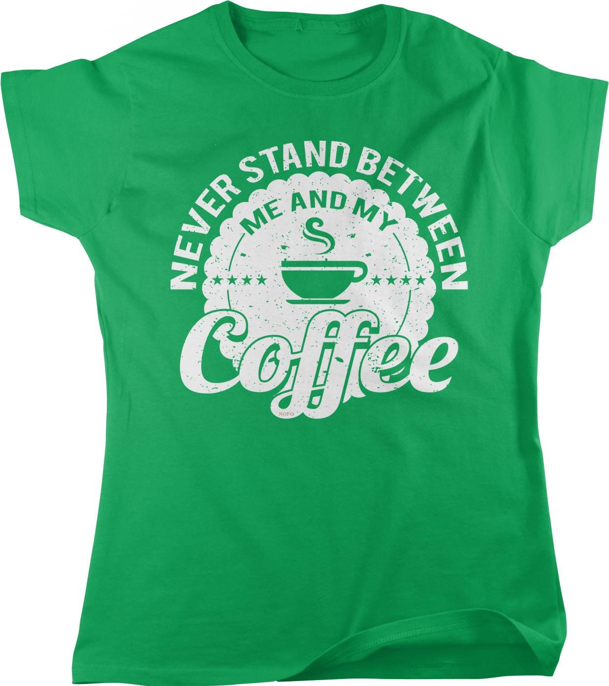A green t-shirt with a white graphic design that says "NEVER STAND BETWEEN ME AND MY COFFEE" along with a coffee cup icon.