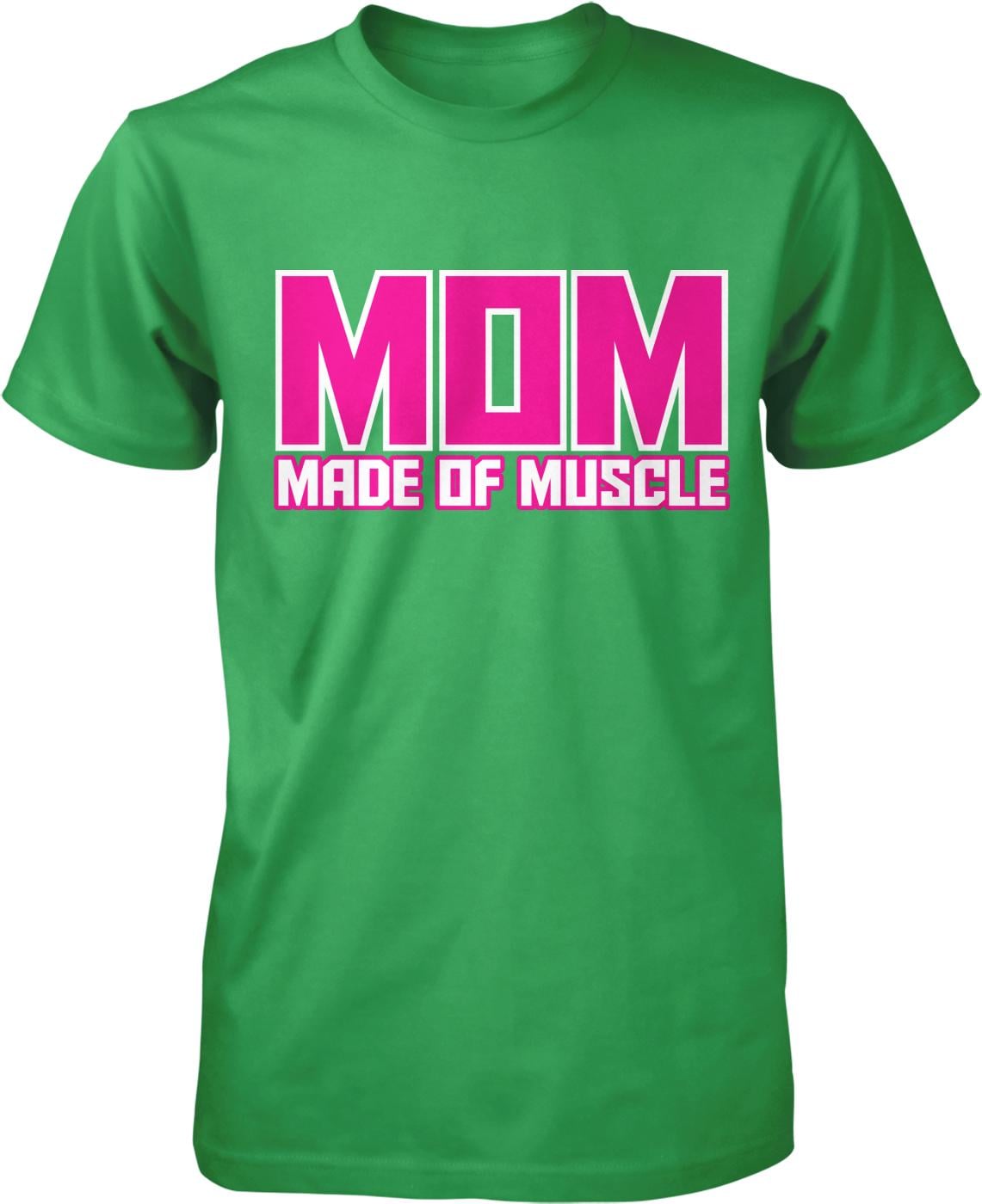 A green t-shirt with the text "MOM MADE OF MUSCLE" printed on it in pink and white letters.
