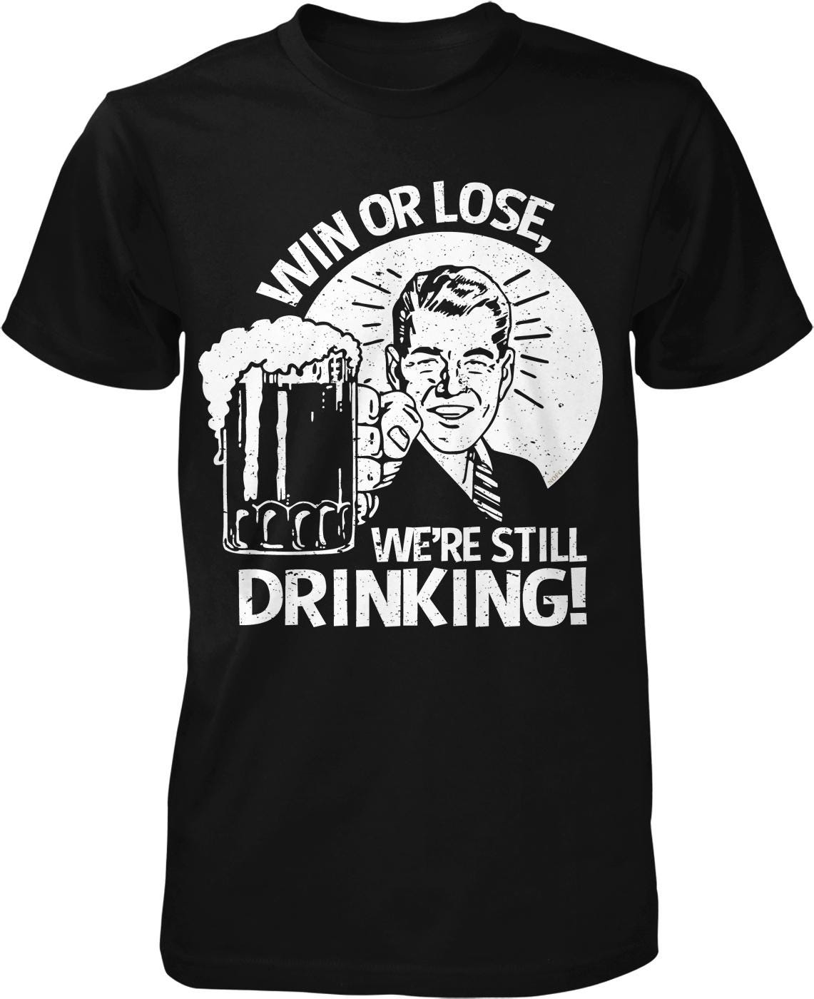 A black t-shirt with a graphic design depicting a man holding a beer mug and making a victory or defeat gesture. The text above the image reads "WIN OR LOSE" and below it says "WE'RE STILL DRINKING!"