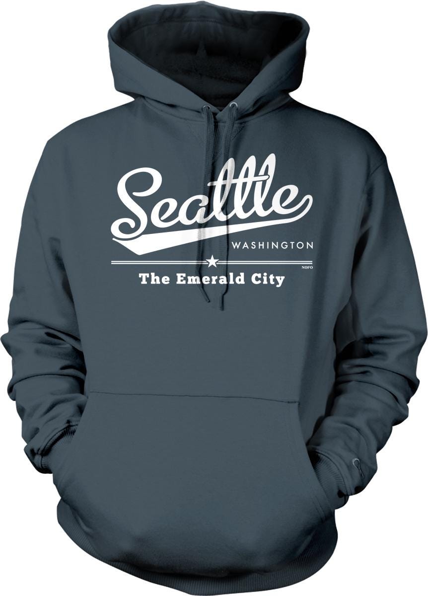 A gray hoodie with white text and graphics that say "Seattle Washington The Emerald City".
