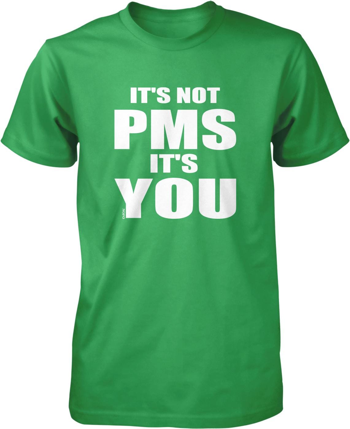 A green t-shirt with white text that reads "IT'S NOT PMS IT'S YOU".