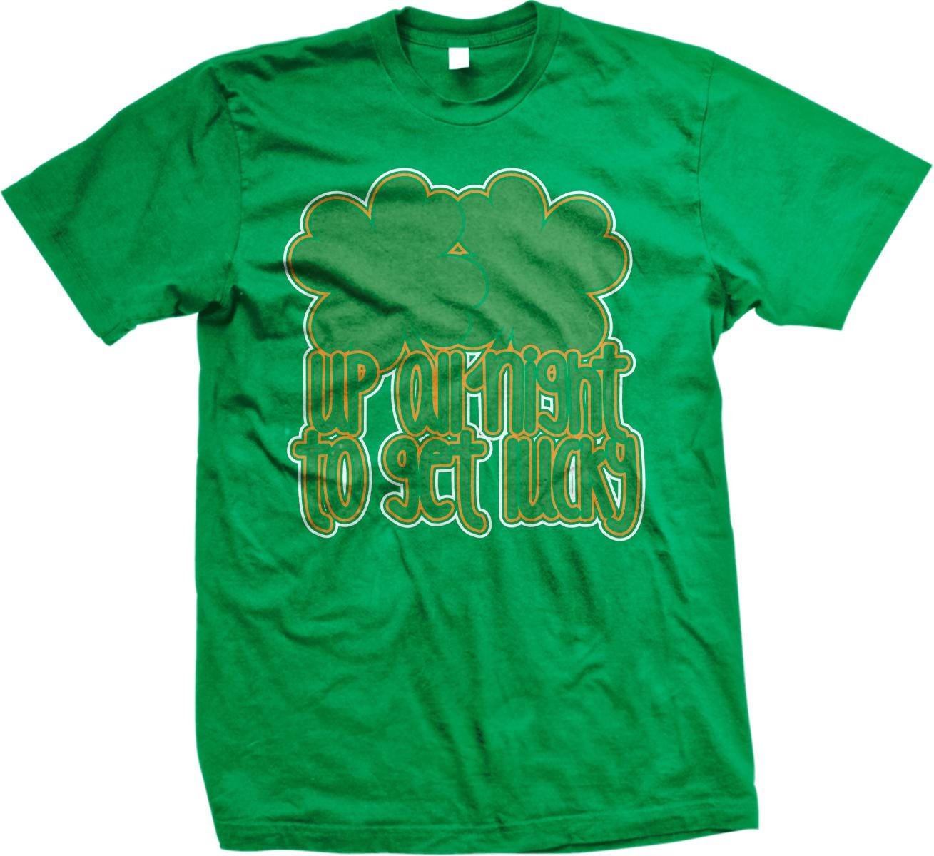 A green t-shirt with a graphic design featuring a cloud-like shape and the text "UP at night to get lucky" printed on it.