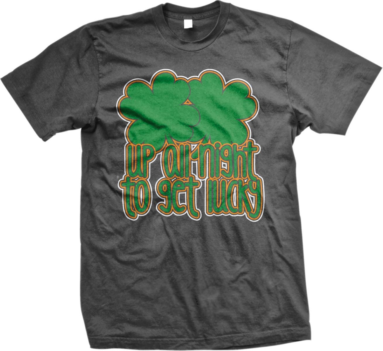 A gray t-shirt with a green and orange design featuring a clover and the text "UP AT NIGHT TO GET LUCKY" printed on it.