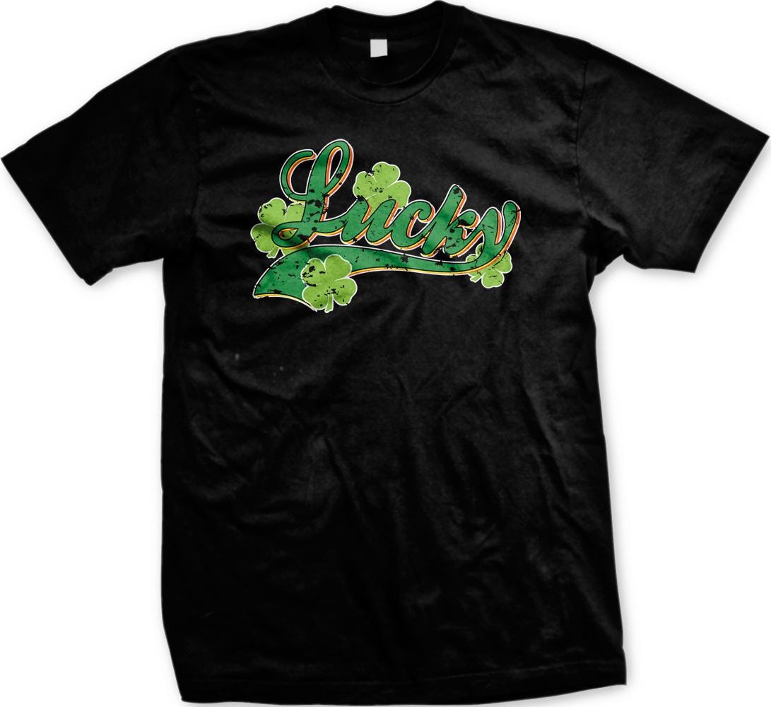 A black t-shirt with a graphic design featuring the word "Lucky" surrounded by green shamrocks.